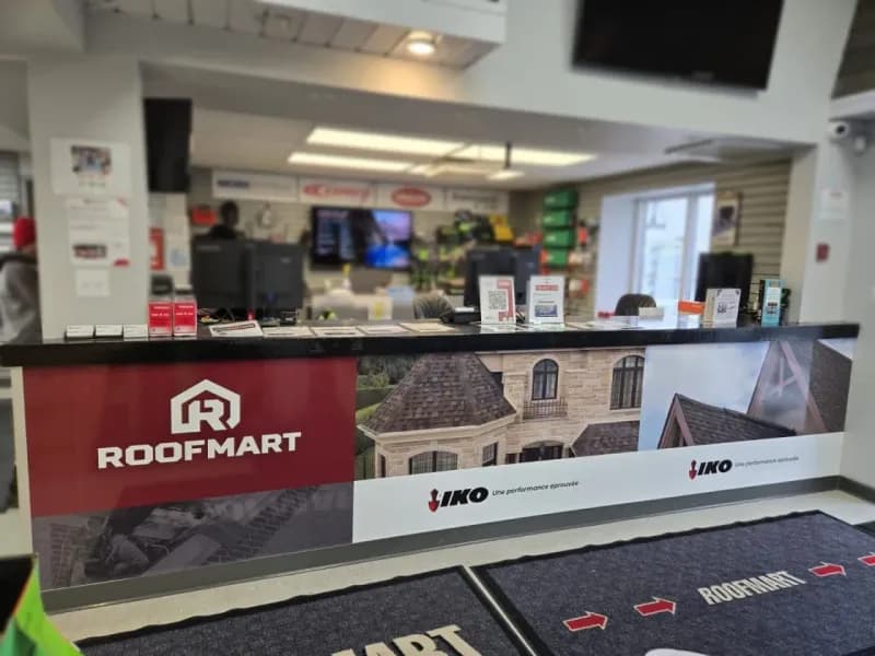 Comptoir de service Roofmart habillé de graphiques et flèches directionnelles au sol