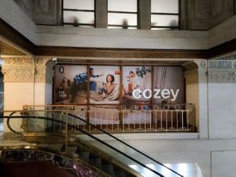 Grande bannière Cozey suspendue dans un centre commercial