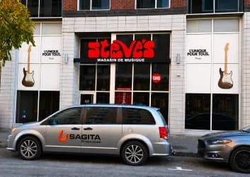 Vitrines de Steve’s Music Store avec graphiques, fourgonnette Sagita devant