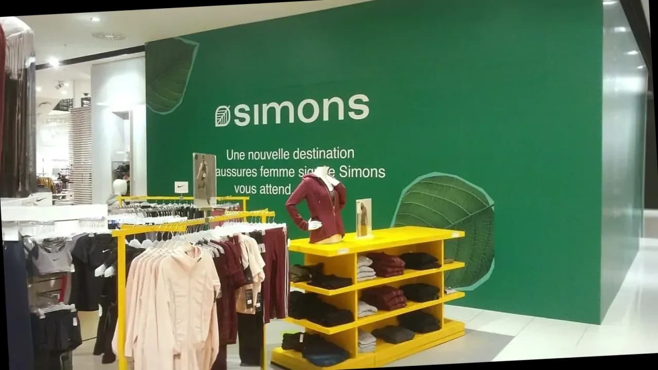 Mur intérieur vert avec logo Simons et motifs de feuillage en magasin